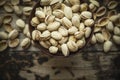 Salted pistachios in a wooden bowl on wooden rustic background, top view Royalty Free Stock Photo