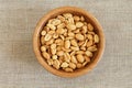 Salted roasted peanuts in bamboo bowl on rough linen cloth Royalty Free Stock Photo