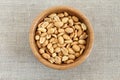 Salted roasted peanuts in bamboo bowl on rough linen cloth Royalty Free Stock Photo