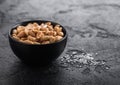 Salted and roasted peanuts classic snack in black bowl on black background Royalty Free Stock Photo