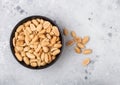 Salted and roasted peanuts classic snack in black bowl on light background Royalty Free Stock Photo