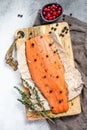 Salted salmon fillet on a wooden cutting Board with herbs and spices. Gray background. Top view