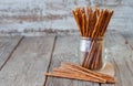 Salted sticks in a glass and on wooden table, with a selective f Royalty Free Stock Photo