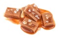 Salted toffee candies with caramel sauce isolated on white background. Golden Butterscotch toffee caramels