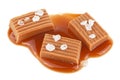 Salted toffee caramel pieces and caramel sauce isolated on white background. Delicious candies