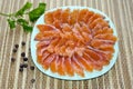 Salted trout slices on a blue plate close-up, allspice and a sprig of parsley Royalty Free Stock Photo