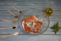 Salting salmon at home, fillet in a transparent bowl olive oil and various spices in wooden spoons Royalty Free Stock Photo