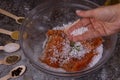 Salting salmon at home, fillet in a transparent bowl olive oil and various spices in wooden spoons Royalty Free Stock Photo