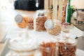 Salty bar of several kinds snacks in glass jars decorated on wooden table with white table cloth. Wedding or party