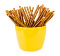 Salty bread sticks in yellow glass cup isolated on white Royalty Free Stock Photo