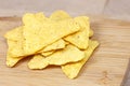 Salty crunchy and crispy triangle mexican corn nachos on light wooden background.