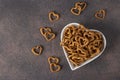 Salty heart-shaped crackers in a heart-shaped plate on a brown background, Snack for Valentines Day Royalty Free Stock Photo
