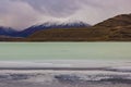 The salty Laguna Amarga in front of the cloudy mountains in Torres del Paine National Park, Chile
