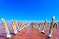 The salty lake with pink water and the beach from salt. Old logs pier on Lake Sasyk in the Crimea Royalty Free Stock Photo