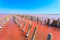 The salty lake with pink water and the beach from salt. Old logs pier on Lake Sasyk in the Crimea Royalty Free Stock Photo