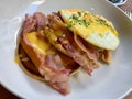 Salty Pancakes with Hollandaise Sauce, Melted Cheddar Cheese, Eggs and Crispy Bacon for Breakfast. Salted Food Royalty Free Stock Photo