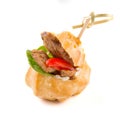 Salty profiterole appetizer with fish on white