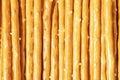 Salty sticks line in row background. Top view. Snack texture background. Salty bread sticks for beer background pattern