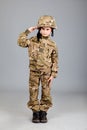 Saluting soldier. Young boy dressed like a soldier