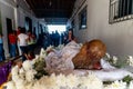 Catholic faithful praying near the statue of the dead Jesus during the Passion of Christ Mass