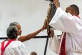 Catholic faithful touch and kiss the statue of Jesus Christ on the cross during Holy Week Mass