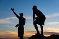 Fishermen on top of the rocks, in silhouette. Royalty Free Stock Photo