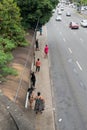 Salvador, Bahia, Brazil - August 11, 2023: Passengers standing waiting for transport at a bus stop on Avenida Tancredo Neves