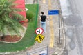 Salvador, Bahia, Brazil - August 11, 2023: A pedestrian walking on the sidewalk between two traffic signs on Avenida Tancredo Royalty Free Stock Photo
