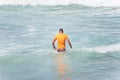 Surfer entering the sea to surf at Farol da Barra beach in the Brazilian city of Salvador Royalty Free Stock Photo