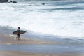 Surfer entering the sea to surf at Farol da Barra beach in the Brazilian city of Salvador Royalty Free Stock Photo