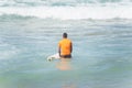 Surfer entering the sea to surf at Farol da Barra beach in the Brazilian city of Salvador Royalty Free Stock Photo