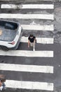 Salvador, Bahia, Brazil - August 11, 2023: View from above of a car and pedestrians crossing the lane on one of the streets next