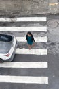 Salvador, Bahia, Brazil - August 11, 2023: View from above of a car and pedestrians crossing the lane on one of the streets next