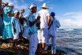 Candomble people stand on top of the rocks at Rio Vermelho beach, offering gifts to Yemanja