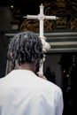 Man entering the catholic church holding the silver cross Royalty Free Stock Photo