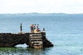 People and tourists are on top of the stone pier of Porto da Barra