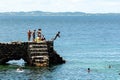 People and tourists are on top of the stone pier of Porto da Barra