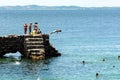 People and tourists are on top of the stone pier of Porto da Barra
