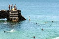 People and tourists are on top of the stone pier of Porto da Barra