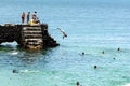 People and tourists are on top of the stone pier of Porto da Barra