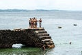 People and tourists are on top of the stone pier of Porto da Barra