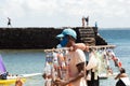 Man selling sunscreen walks on beach