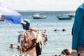 Man selling sunscreen walks on beach