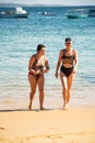 Salvador, Bahia, Brazil - June 04, 2022: Mother and daughter, in bikinis, are coming out of the water at Porto da Barra beach in