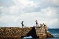 People walk on top of the stone breakwater Royalty Free Stock Photo
