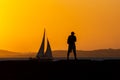A person, in silhouette, is seen on the Porto da Barra pier against the sunset in the city of Salvador, Bahia Royalty Free Stock Photo
