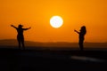 Two people, in silhouette, are seen on the Porto da Barra pier against the sunset in the city of Salvador, Bahia Royalty Free Stock Photo