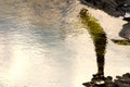 Salvador, Bahia, Brazil - October 13, 2019: Reflection of a person crossing the water puddles of the rocks of Farol da Barra beach Royalty Free Stock Photo