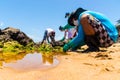 Volunteers remove black oil from the Rio Vermelho beach spilled by a ship in the Brazilian sea