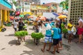 Boys selling salad greens on the street in front of the Public market of Itapua
